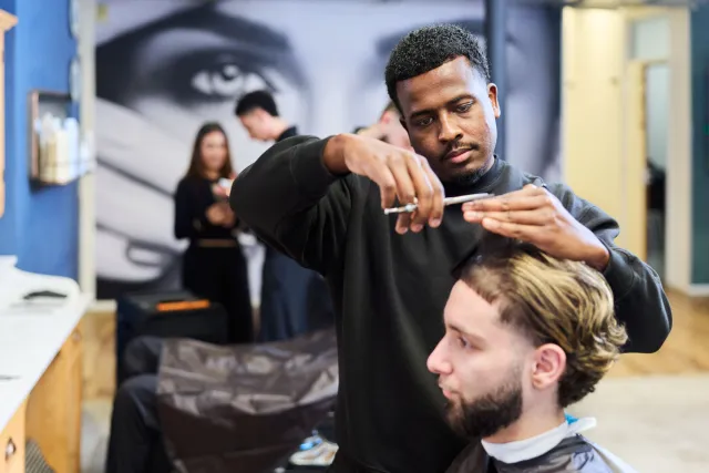 Student Salonmanager Barbier knipt haar van klant