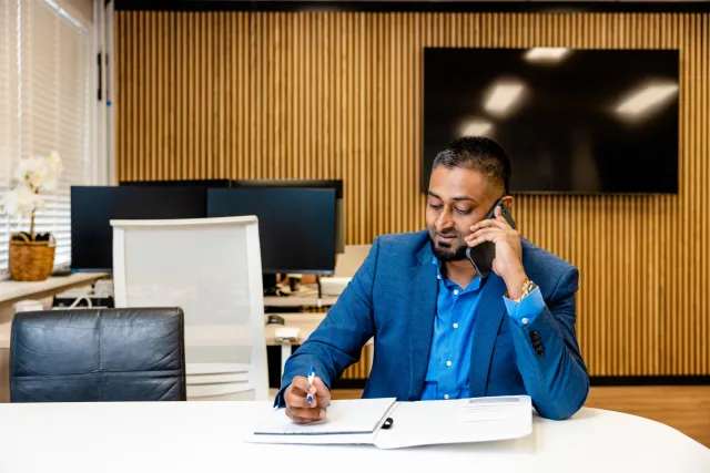 Commercieel medewerkers zit aan de telefoon en maak aantekeningen.