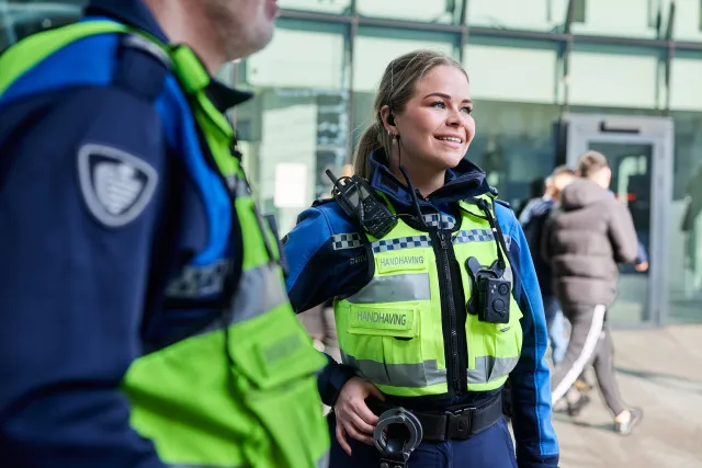 Twee handhavers aan het werk op het station.