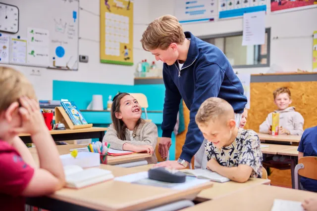 Leerling stelt vraag aan student Onderwijsassistent