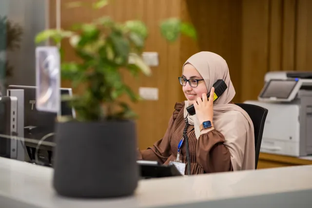 Een medisch secretaresse is in gesprek aan de telefoon.