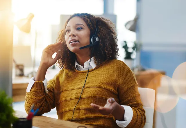 Een medische secretaresse voert een triagegesprek met een headset op.