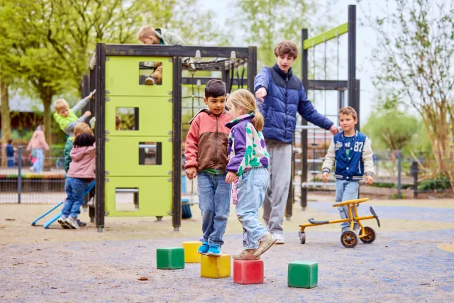 Pedagogisch medewerker begeleidt kinderen op het schoolplein
