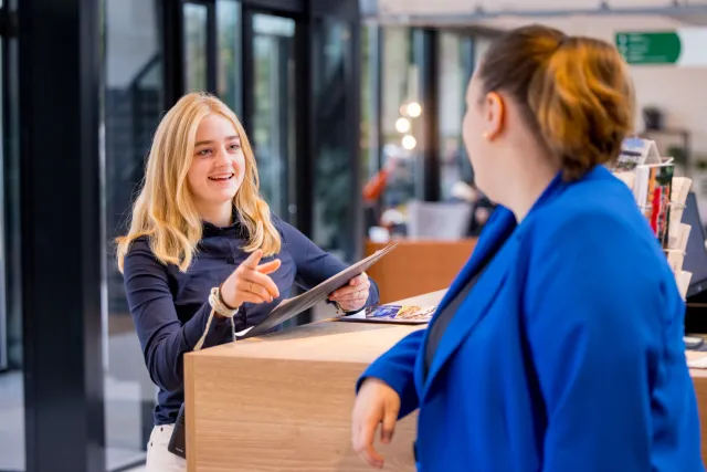 Student Event Manager staat bij balie