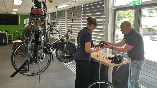 Sudent opleiding Fietstechnicus krijgt uitleg van docent in werkplaats.