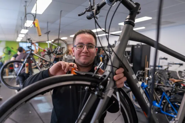 Student opleiding Fietstechnicus werkt aan fiets in werkplaats.