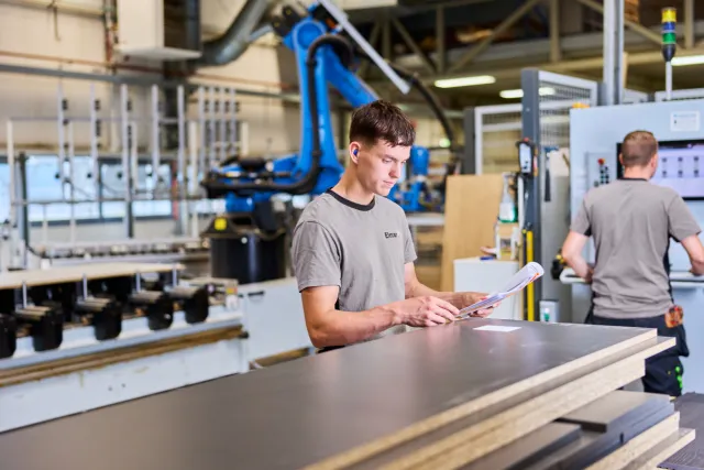 Student Meubelmaken bestudeert werktekening op de werkplaats