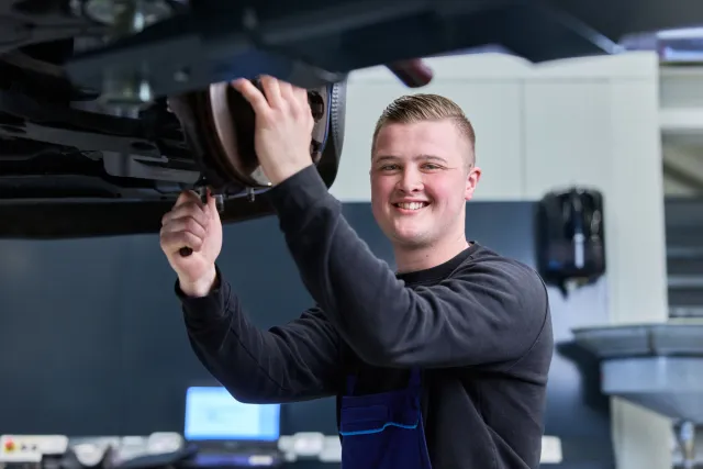 Student Autotechniek sleutelt aan een auto in de werkplaats