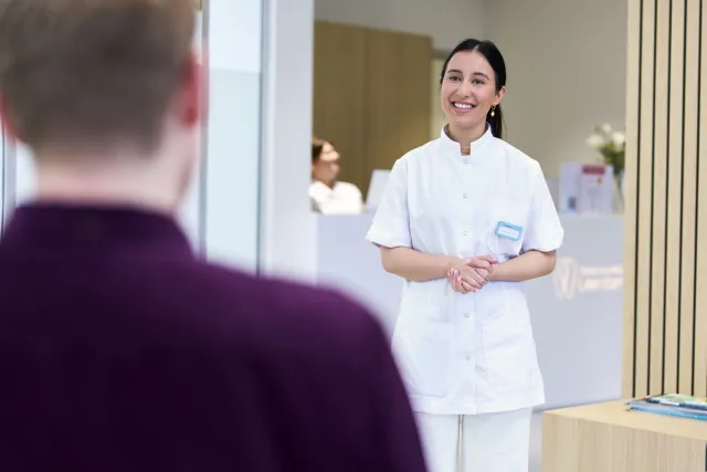 Student Tandartsassistent haalt patiënt op in wachtruimte