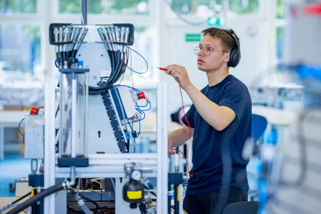 Student Techniek werkt met pneumatiekbord