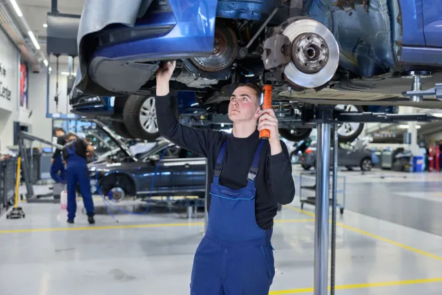 Student Autotechniek werkt aan auto met licht