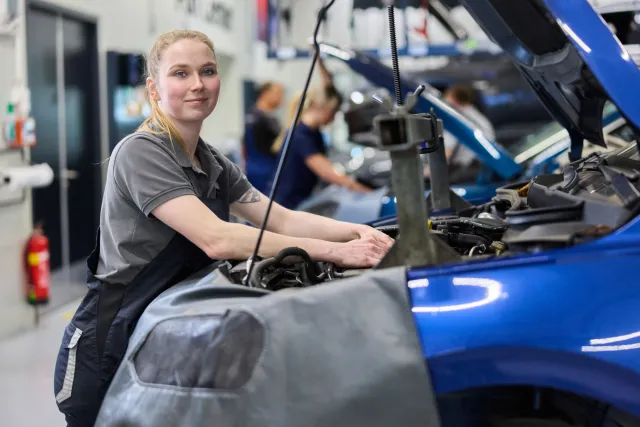 Student Autotechniek werkt onder de motorkap van een auto