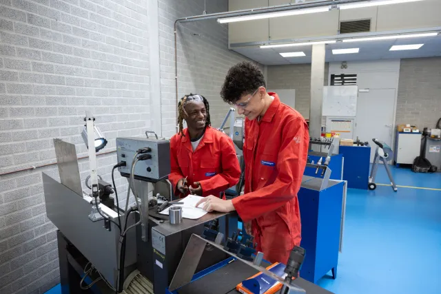 Studenten Flexopleiding Medewerker Techniek lachen bij metaalbewerkingsmachine
