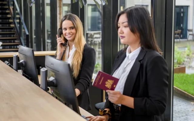 Studenten Leidinggevende Toerisme & Recreatie werken achter een reisbalie