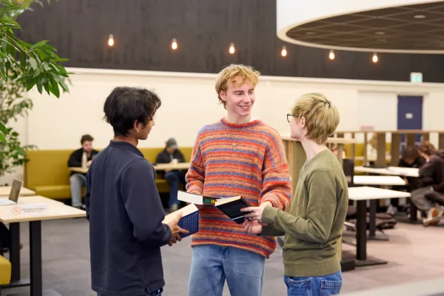 Studenten VAVO Lyceum praten met elkaar in de bibliotheek op school