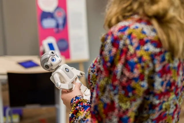 Deelnemer keuzedeel Zorg en technologie houdt zorgrobot vast in hand.