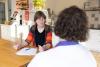 Praktijkopleider in gesprek over kwaliteitsborging met collega aan tafel.