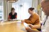 Praktijkopleider speelt aan tafel spel met coachkaarten met 2 werkbegeleiders.
