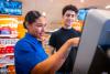 Retailspecialist helpt klant met afrekenen.