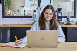 Sam, student Software Developer, werkt aan code achter computer