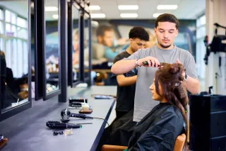 Student Haarstylist maakt het haar van een klant mooi