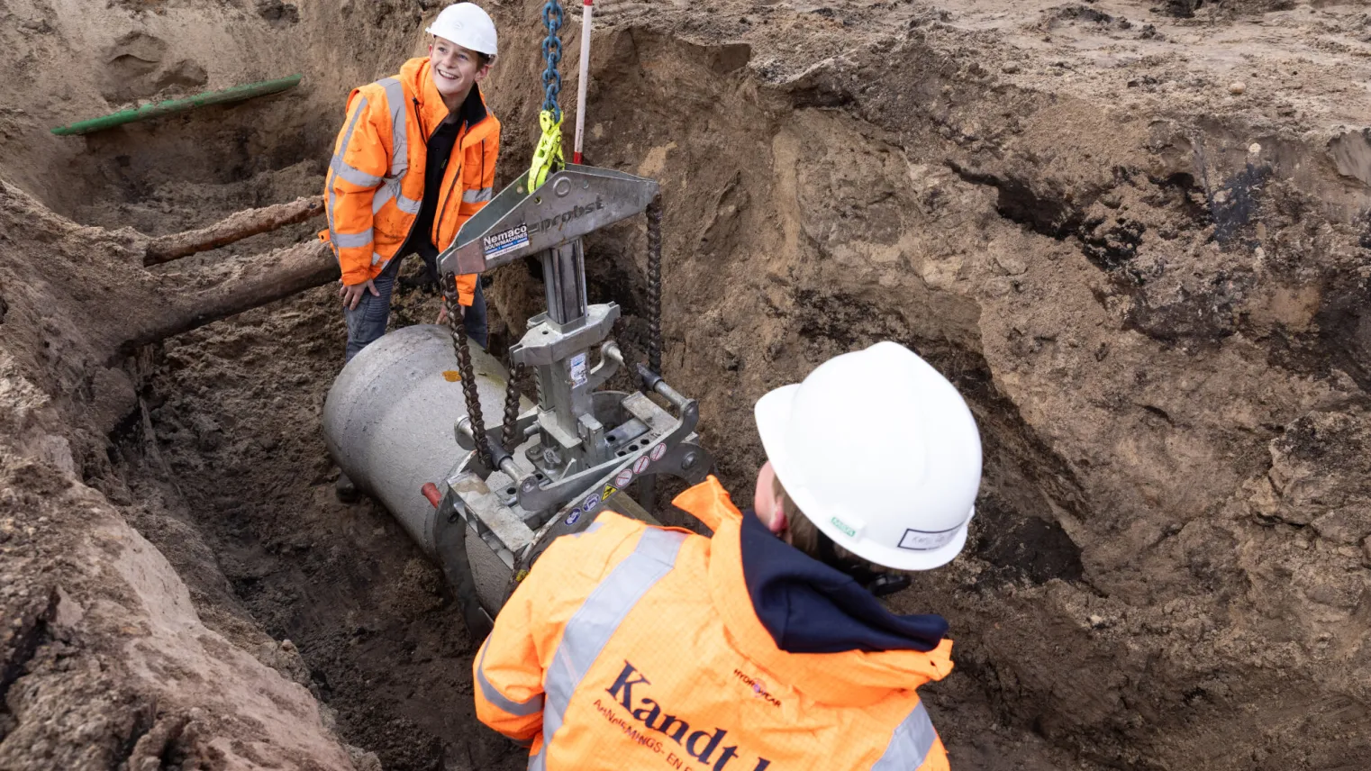 Studenten zijn bezig met het installeren van een rioolbuis