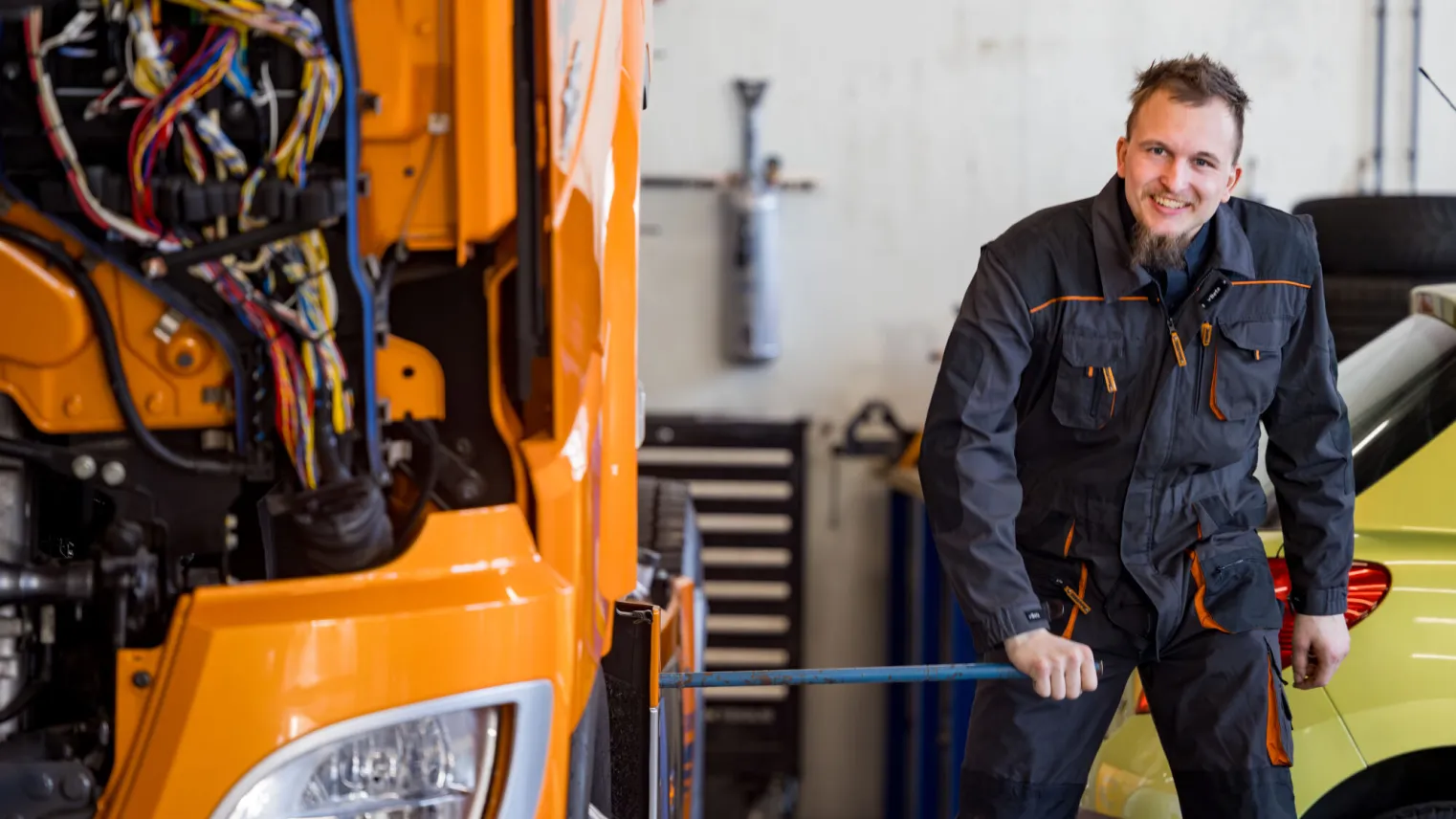 Allround Bedrijfsautotechnicus staat naast een vrachtwagen in de Truck Academy
