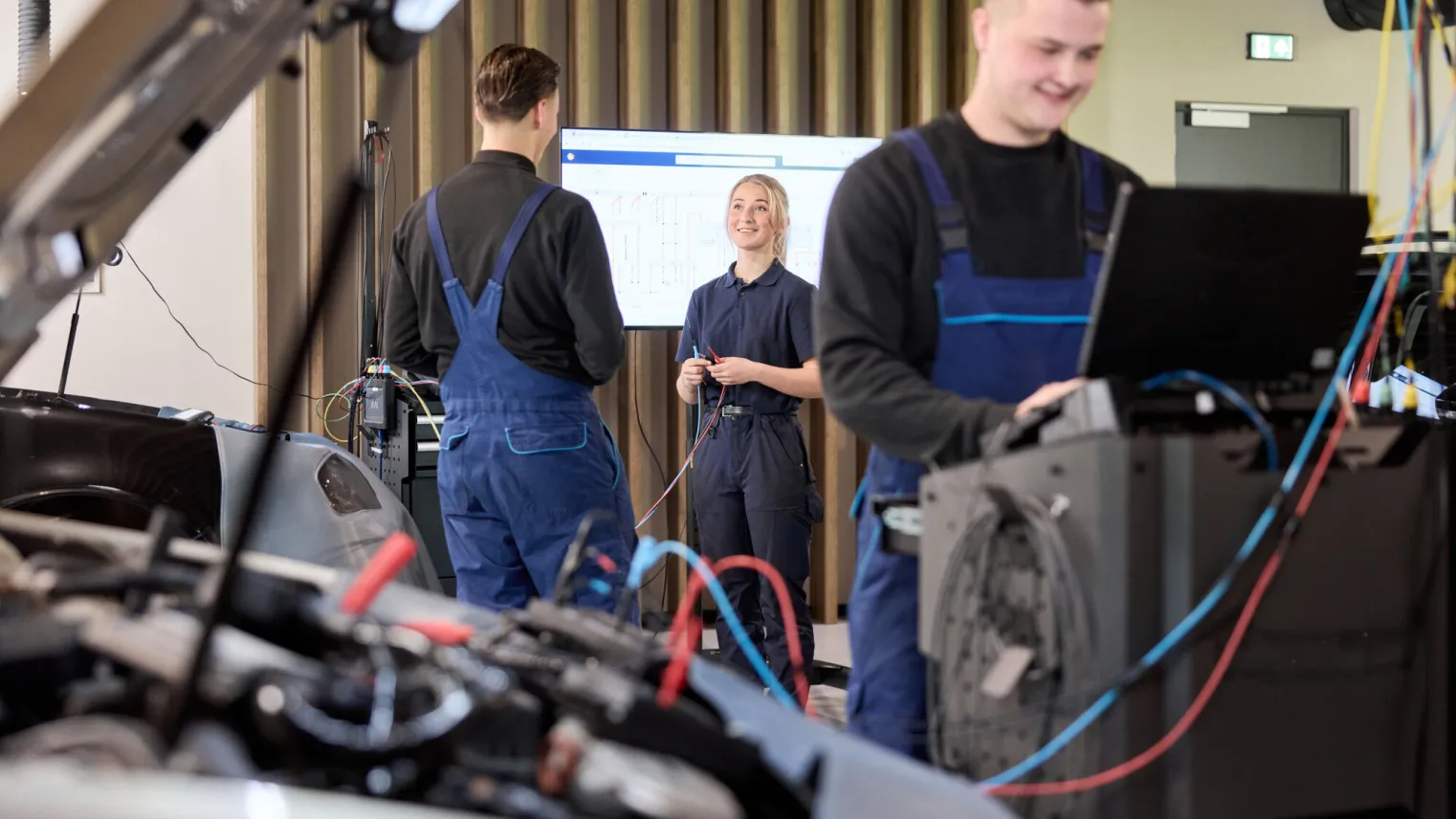 Studenten Automotive College werken samen in een werkplaats voor auto's