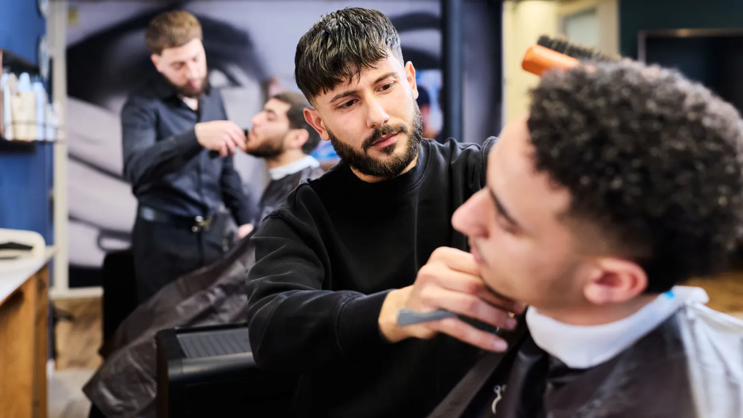 Barbier student scheert klant in de salon op school