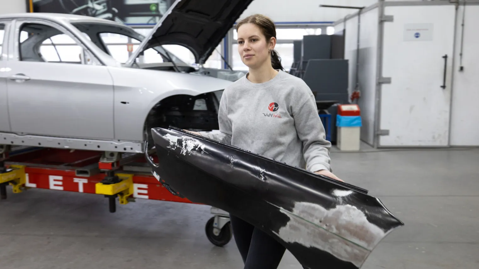 Student verplaatst auto onderdelen om te repareren