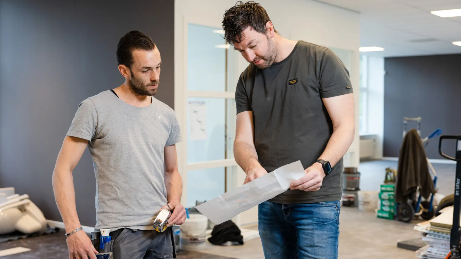 Twee studenten van de basisopleiding Bouwkunde bekijken tijdens een project hun bouwtekening