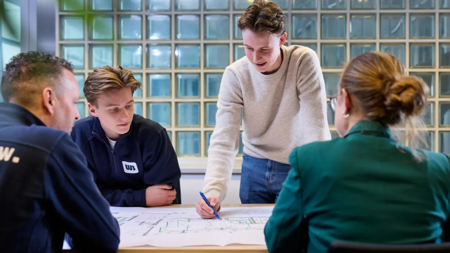 Collega's werken samen aan bouwtekeningen smart building