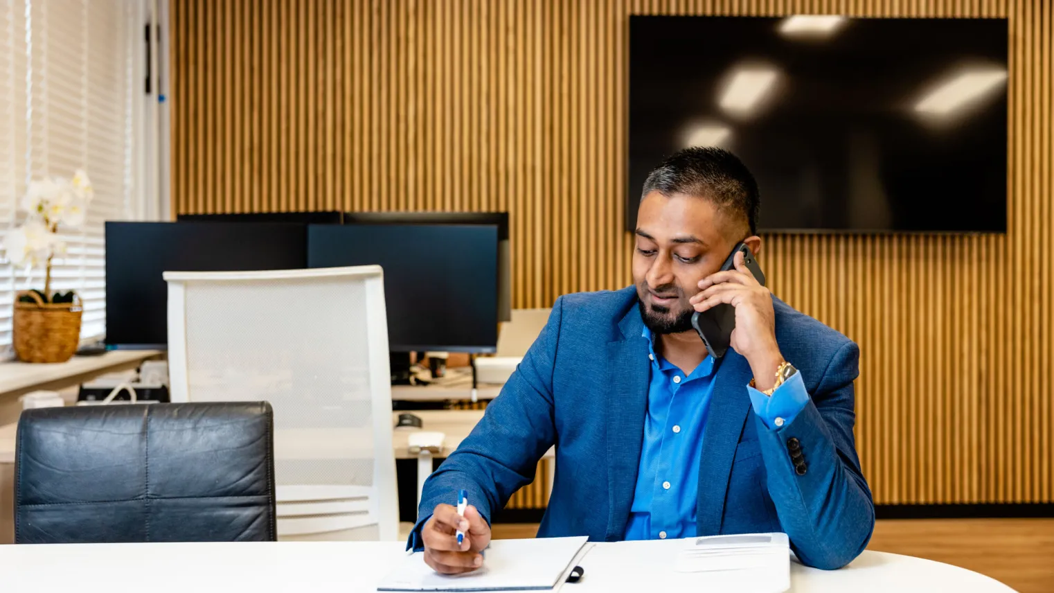 Commercieel medewerkers zit aan de telefoon en maak aantekeningen.
