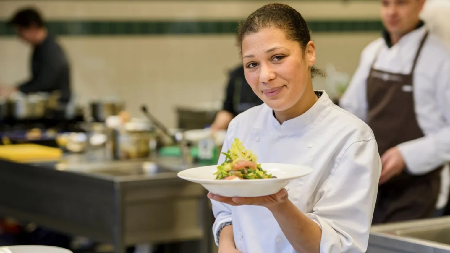 Cursist kok met mooi opgemaakt bord eten