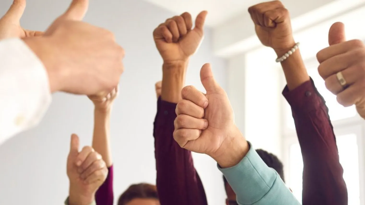 Mensen op kantoor doen hun duimen omhoog.