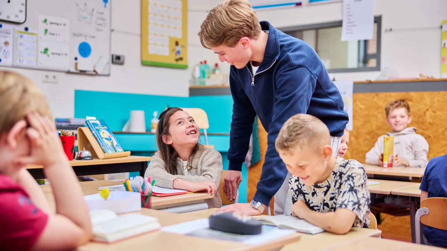 Leerling stelt vraag aan student Onderwijsassistent