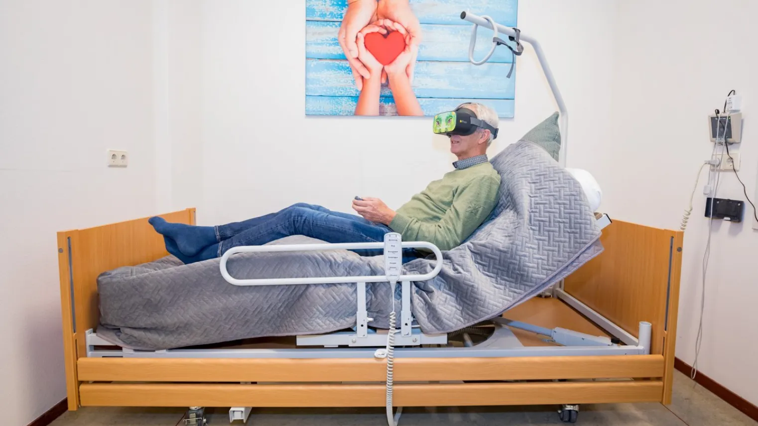 Een man met een VR-bril op zijn hoofd ligt in een ziekenhuisbed.