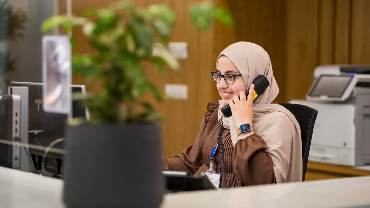 Een medisch secretaresse is in gesprek aan de telefoon.
