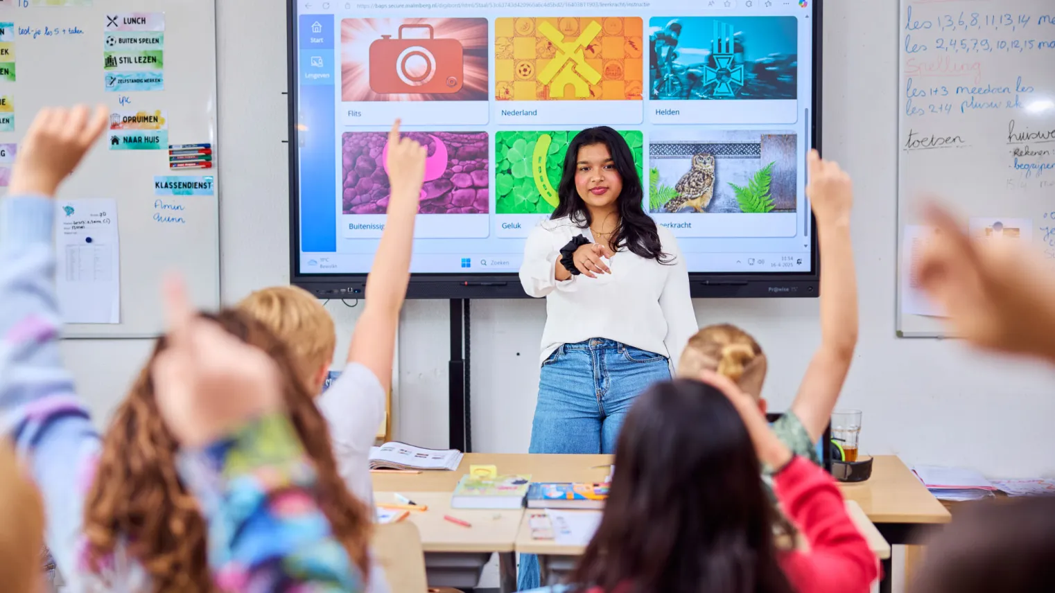 Onderwijsassistent geeft les aan leerlingen uit groep 7