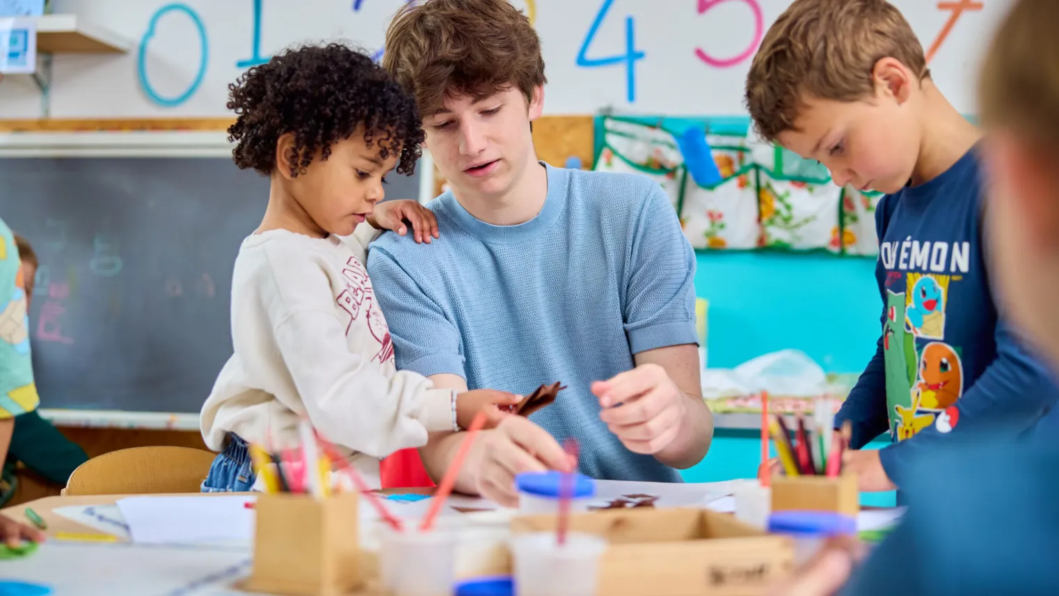Pedagogisch medewerker aan het knutselen met kleuters