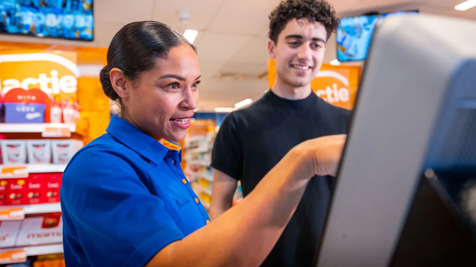 Retailspecialist helpt klant met afrekenen.