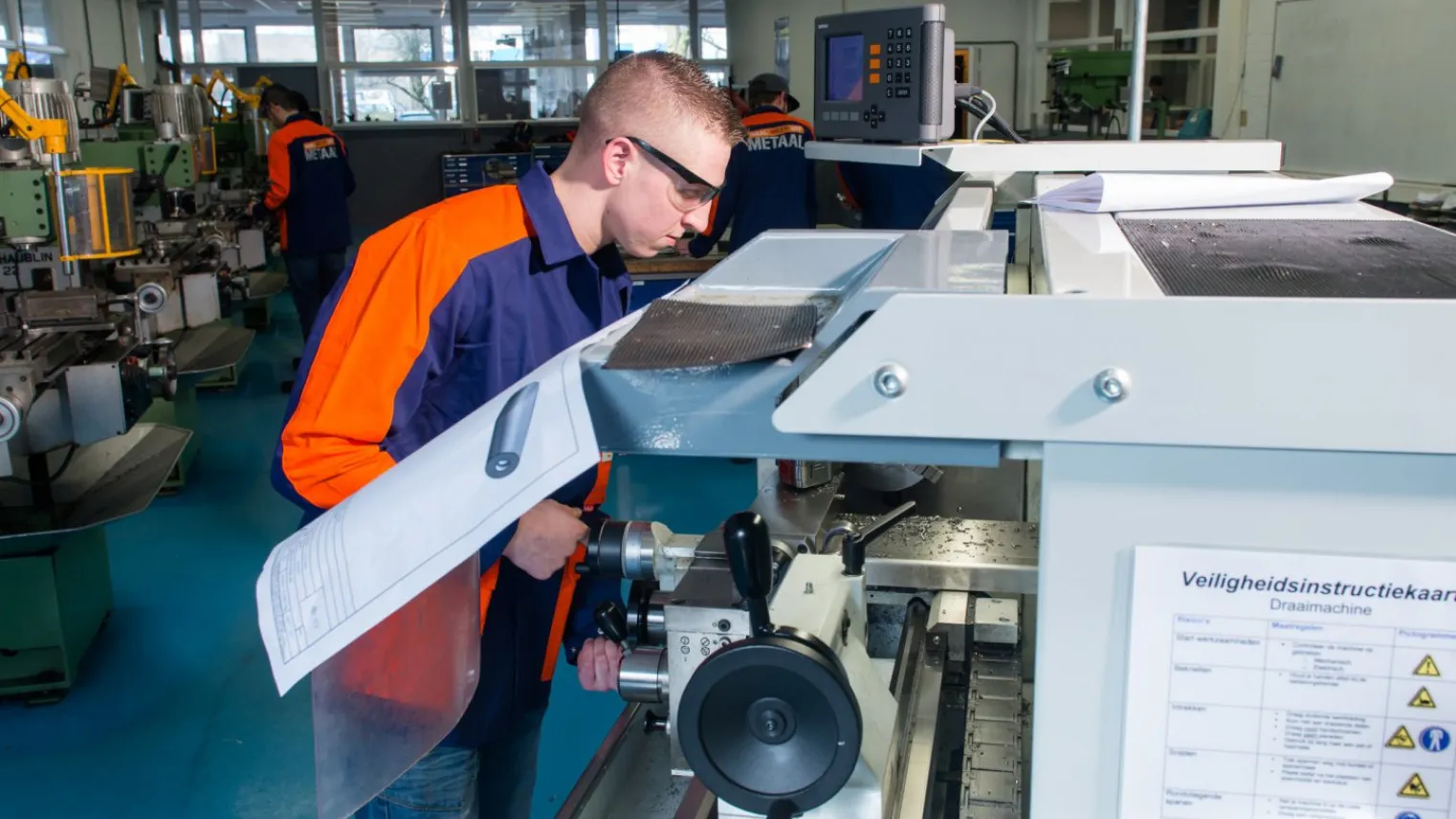 Student Verspanen werkt met een draaimachine in werkplaats