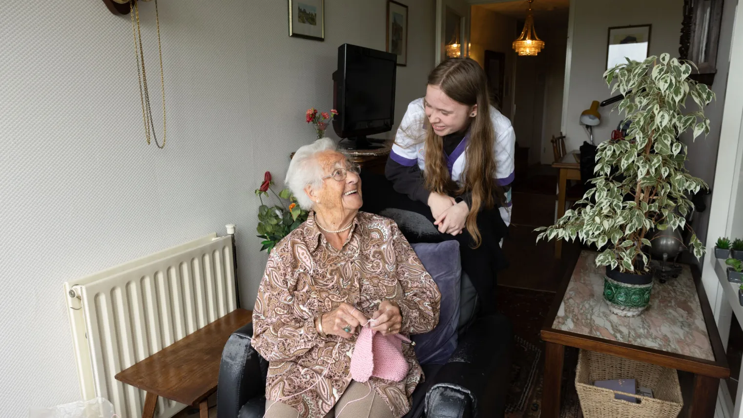 Student Flexopleiding Medewerker Helpende Zorg praat met breiende bewoner