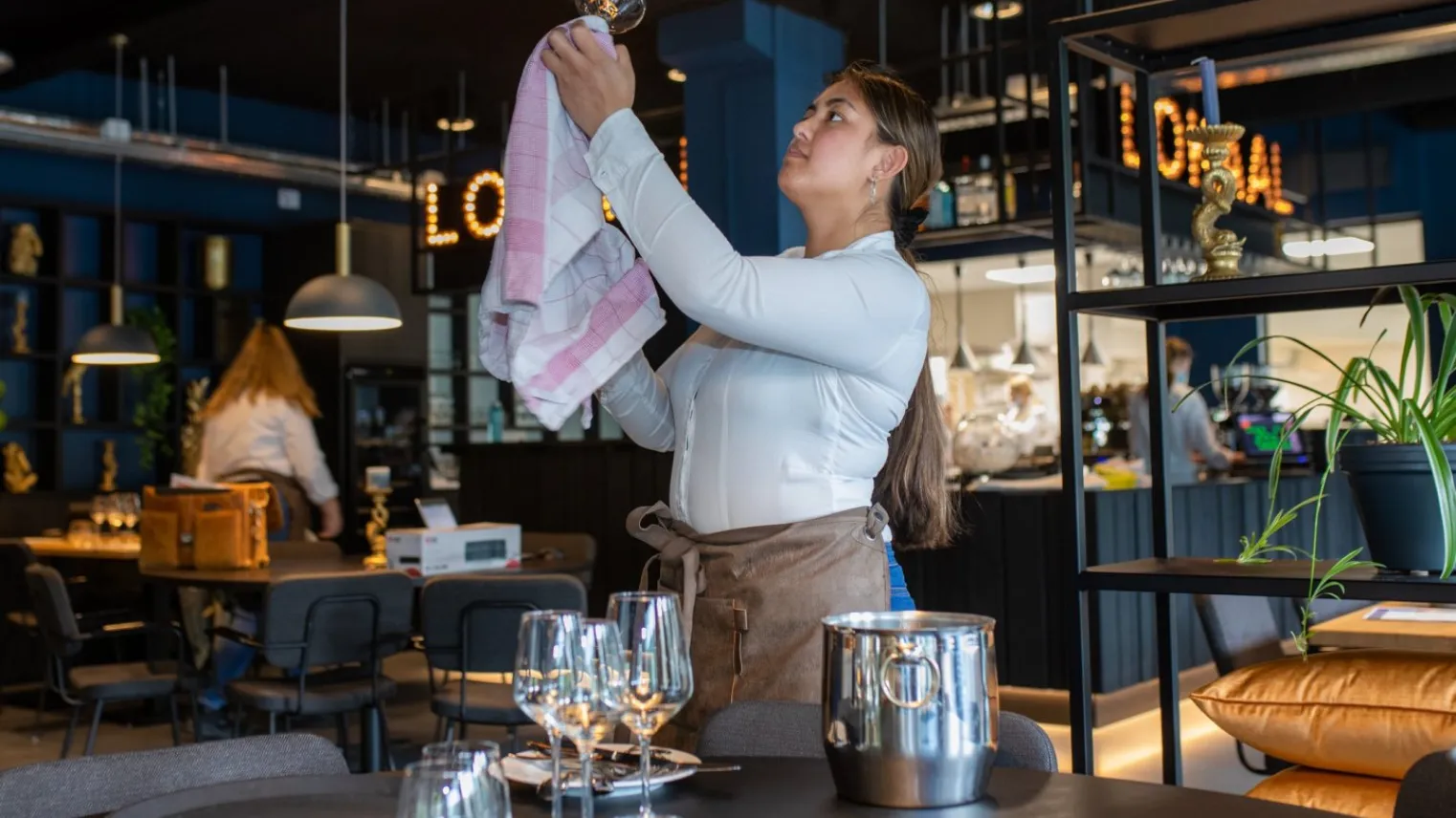 Student Horeca maakt glas schoon in leerrestaurant Het Lokaal