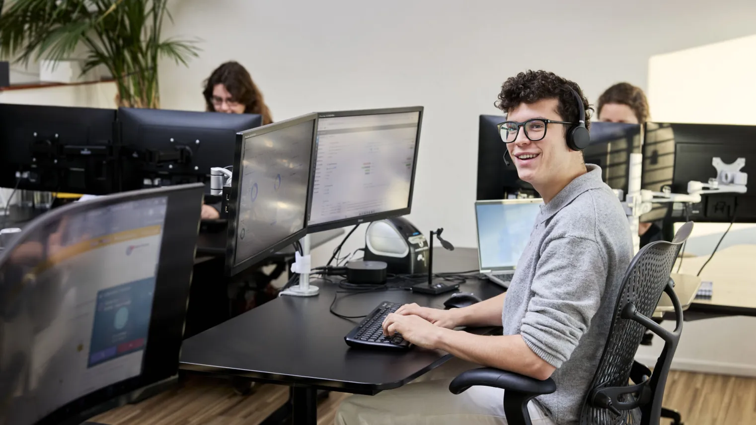 Student ICT werkt met plezier op computer op stageplek