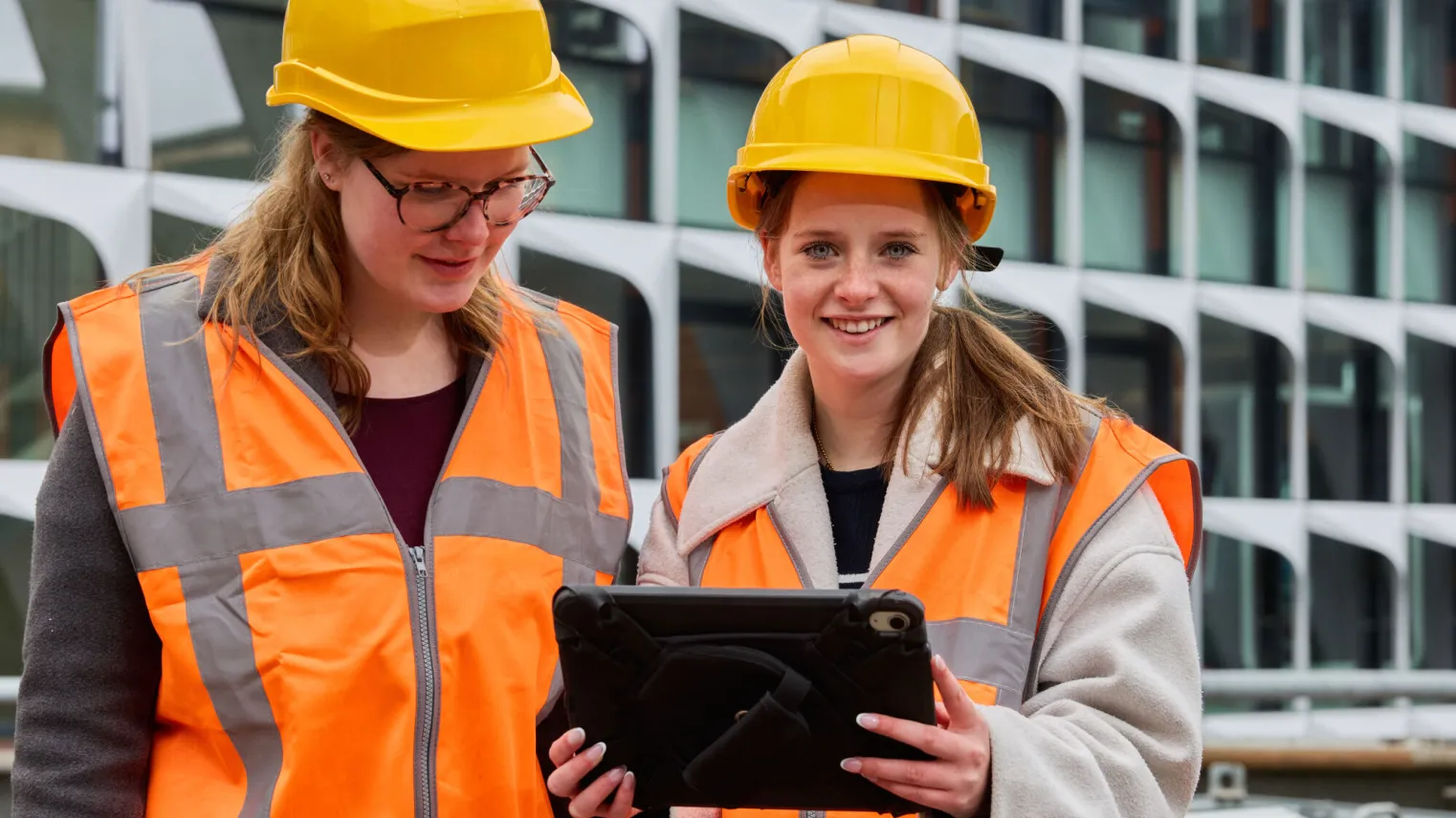Student kijkt op van tablet en lacht