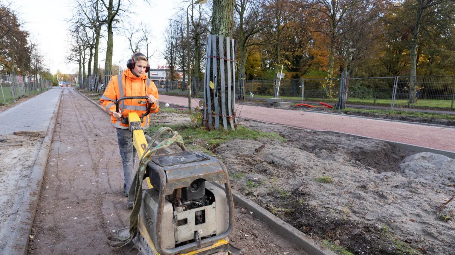 Student Machinist Wegenbouw werkt met een machine op straat