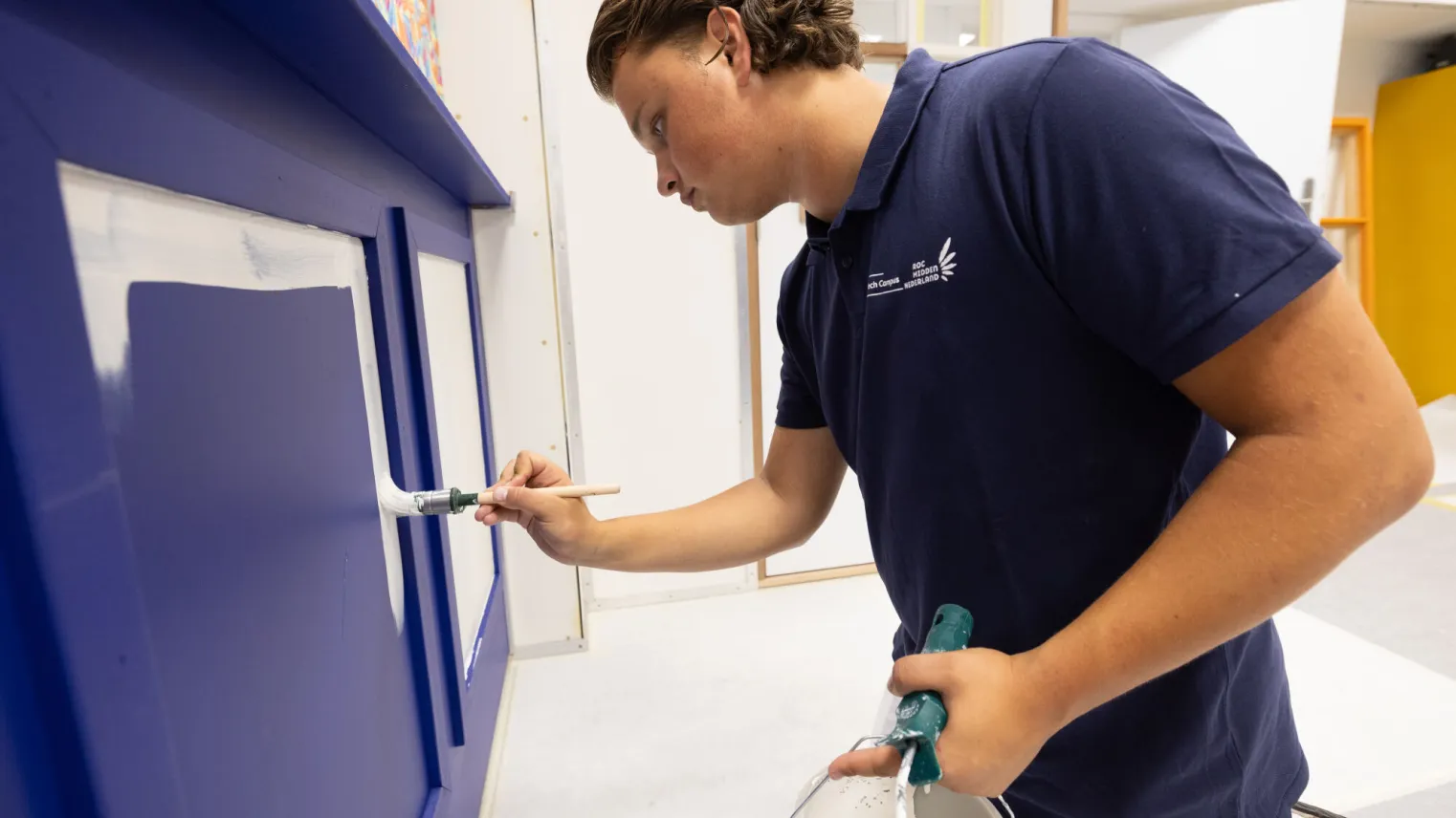 Student Schilder oefent in het praktijklokaal met schilderen