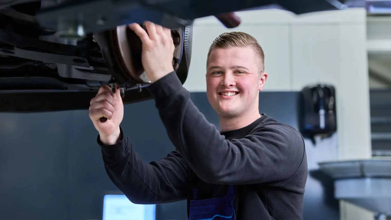 Student Autotechniek sleutelt aan een auto in de werkplaats