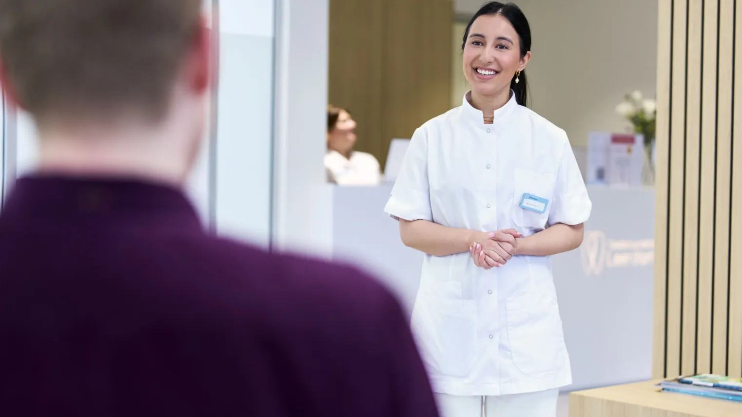 Student Tandartsassistent haalt patiënt op in wachtruimte